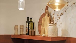 Uno scaffale di legno con bottiglie, un'asse di legno e un vaso.