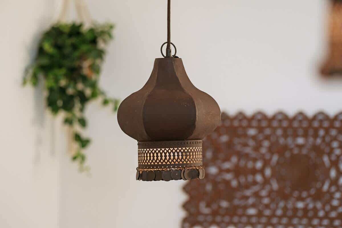 Een hanglamp met een structuurrijke voet en een eenvoudig, gebogen ontwerp.