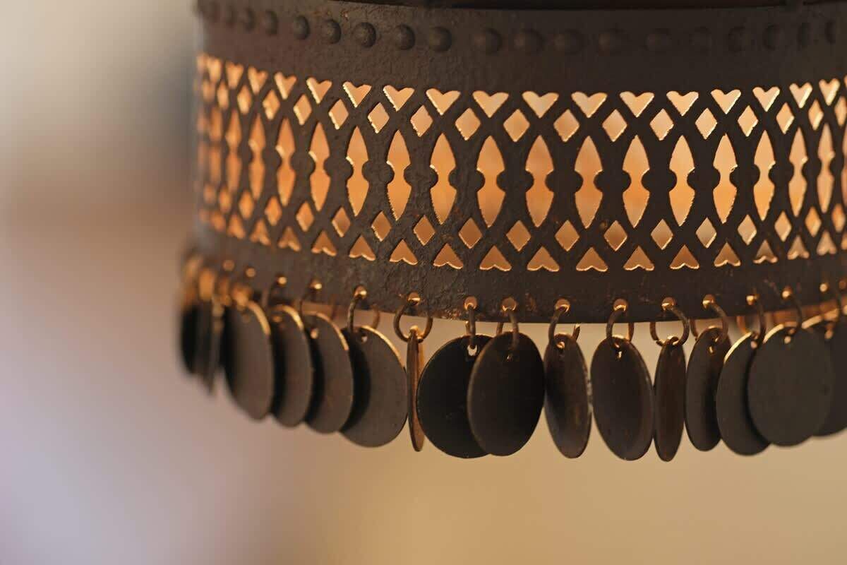 A metal lamp with a lattice design and hanging circular elements.