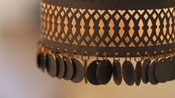 A metal lamp with a lattice design and hanging circular elements.
