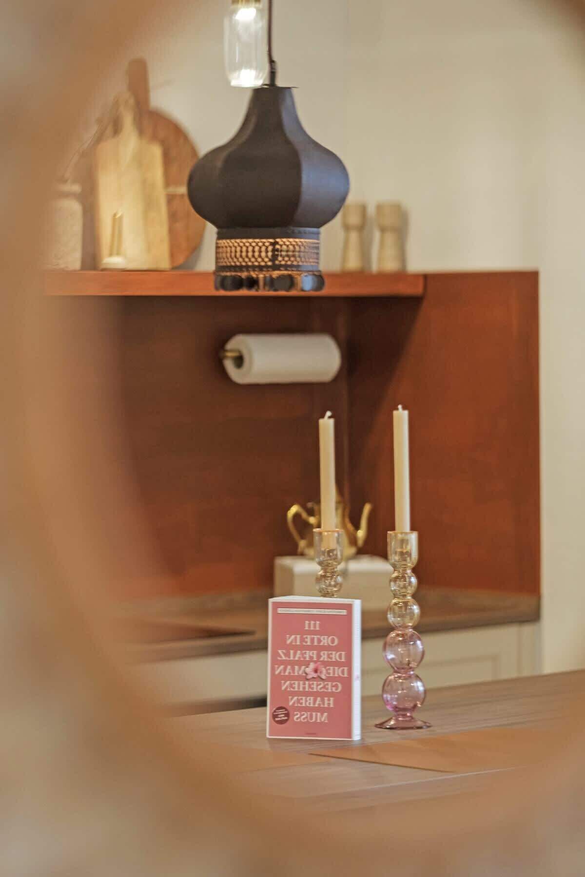 Une étagère ornée d’une lampe décorative, de bougies et d’un livre intitulé « MUSÉE ».
