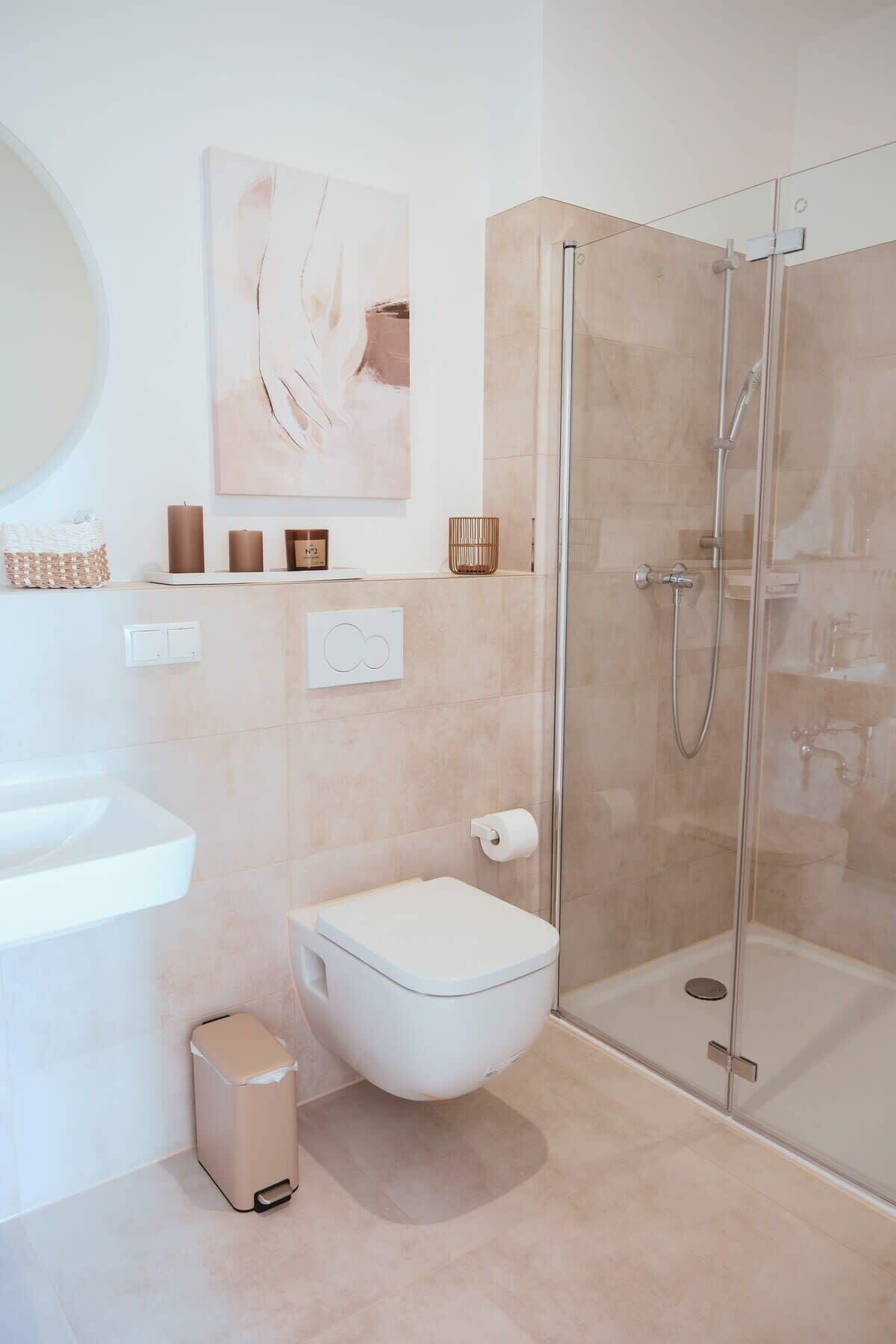 Een moderne badkamer met toilet, bidet en douchecabine met glazen wanden.