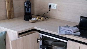 Cozinha com armário embutido, cafeteira e pratos empilhados.