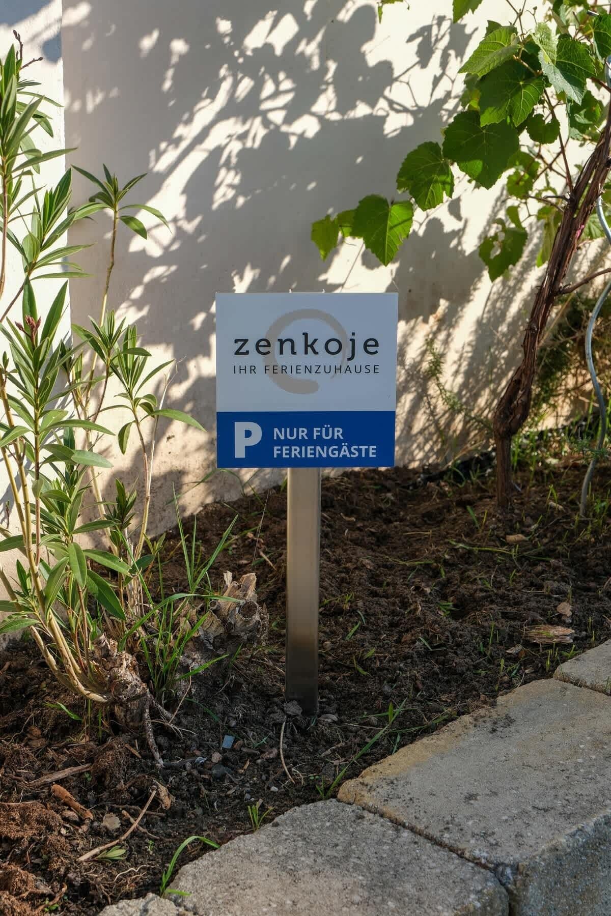 Een bord met daarop 'zenkoje IHR FERIENZUHAUSE' en een parkeerbeperking voor 'alleen gasten'.