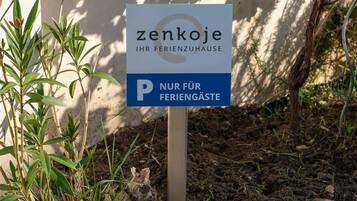 Een bord met daarop 'zenkoje IHR FERIENZUHAUSE' en een parkeerbeperking voor 'alleen gasten'.