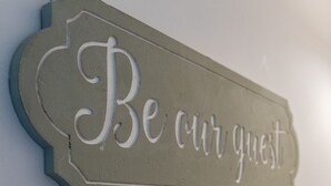 Un cartello con la scritta 'Be our guest' su un muro.