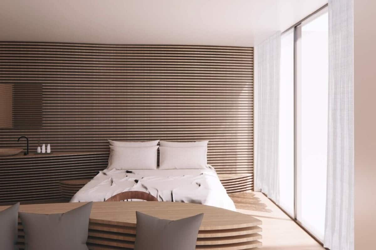 Ein modernes Schlafzimmer mit Bett, Nachttisch und Ausblick nach draußen.