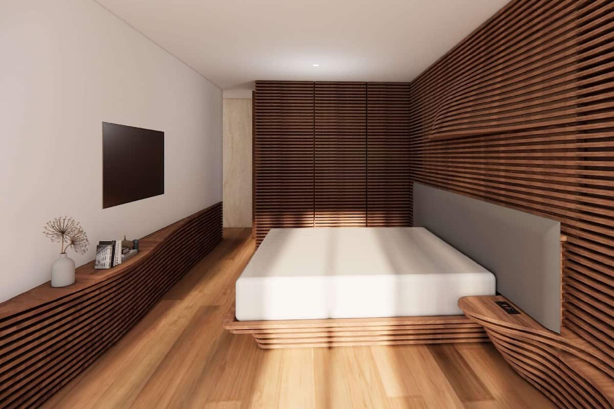 Ein modernes Schlafzimmer mit Wandgestaltung aus Holzlamellen, einem Bett, einem Nachttisch mit einer Vase und einem an der Wand montierten Fernseher.