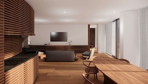 A modern kitchen with a curved wooden countertop, a built-in sink, and a flat-screen TV mounted on the wall. - Romeo Massa Lubrense (Massa Lubrense)