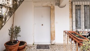 A white door with a small keyhole, a potted plant to the left, and a metal gate to the right. - Ortigia in Giallo by Wonderful Italy (Siracusa)