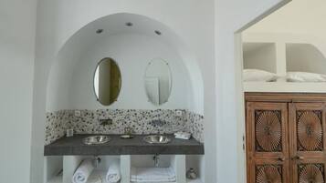Une salle de bain avec un double vasque, deux miroirs et un meuble en bois doté de panneaux décoratifs.