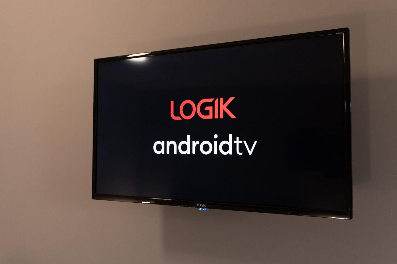 Ein flachbildfernseher an der Wand, der den Text 'LOGIK androidtv' anzeigt.