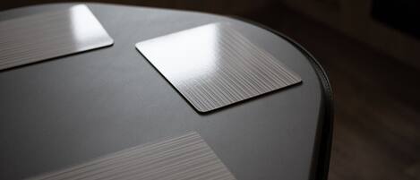 A round table with three metallic placemats.