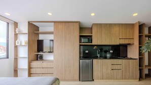 Eine moderne Küche mit Holzschränken, einem Kühlschrank und einer Mikrowelle.