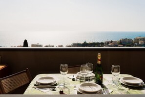A table set for dining with a view of the sea and buildings. - GuestHost - Cozy 32 sq m apartment, perfect for three people, located on the second floor of a former residence with elevator (NOT accessible to disabled guests).The property is located in a quiet area of ​​Sanremo and offers various condominium amen (Sanremo)
