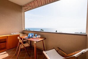 A balcony with a wooden desk, a laptop, and a view of the sea. - GuestHost - Cozy 32 sq m apartment, perfect for three people, located on the second floor of a former residence with elevator (NOT accessible to disabled guests).The property is located in a quiet area of   ​​Sanremo and offers various condominium amen (Sanremo)