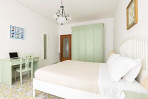 A bedroom with a bed, a desk, a chair, a wardrobe, and a chandelier. - Holiday Home 'Casa Tina' with Private Pool, Wi-Fi, and Air Conditioning (Sorrento)