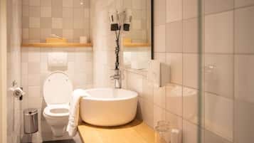Un bagno con il water, un lavandino e un portascopevoli.