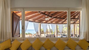 Una habitación con sofá, vista al mar y un espacio exterior cubierto.