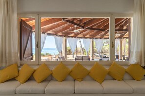 A room with a sofa, a view of the sea, and a covered outdoor area. - Villa Fernanda – elegance, space and panoramic views in Santa Margherita di Pula ✨🌿 (Santa Margherita di Pula)