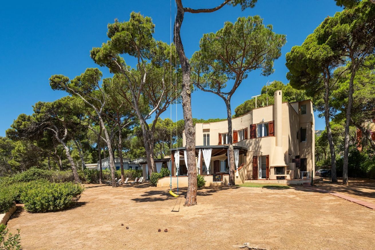 Un bâtiment à deux étages doté d’un patio, entouré d’arbres.