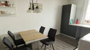 Eine moderne Küche mit Esstisch, Stühlen und einer Mikrowelle.