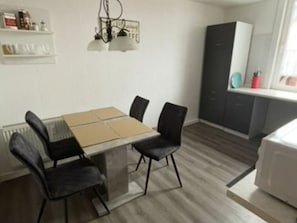 A modern kitchen with a dining table, chairs, and a microwave. - House Cronenberg in the Harz Mountains (Wernigerode)
