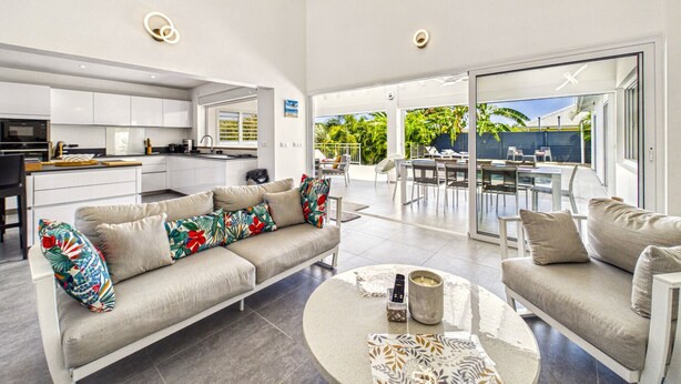 Una sala de estar moderna con un sofá, una mesa de centro y vistas del patio exterior.