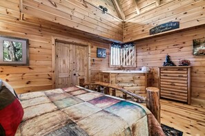 L’intérieur d’une cabane est agrémenté de murs en bois, d’un lit recouvert d’une couverture aux couleurs vives, d’un banc en bois, d’un évier et d’une pancarte sur laquelle on peut lire : « Le meilleur endroit pour être ensemble ».
