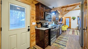 Une cuisine avec des meubles en bois, un four à micro-ondes, une cuisinière et un réfrigérateur.
