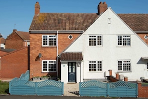 A two-story residential building with a brick facade and a white upper section.