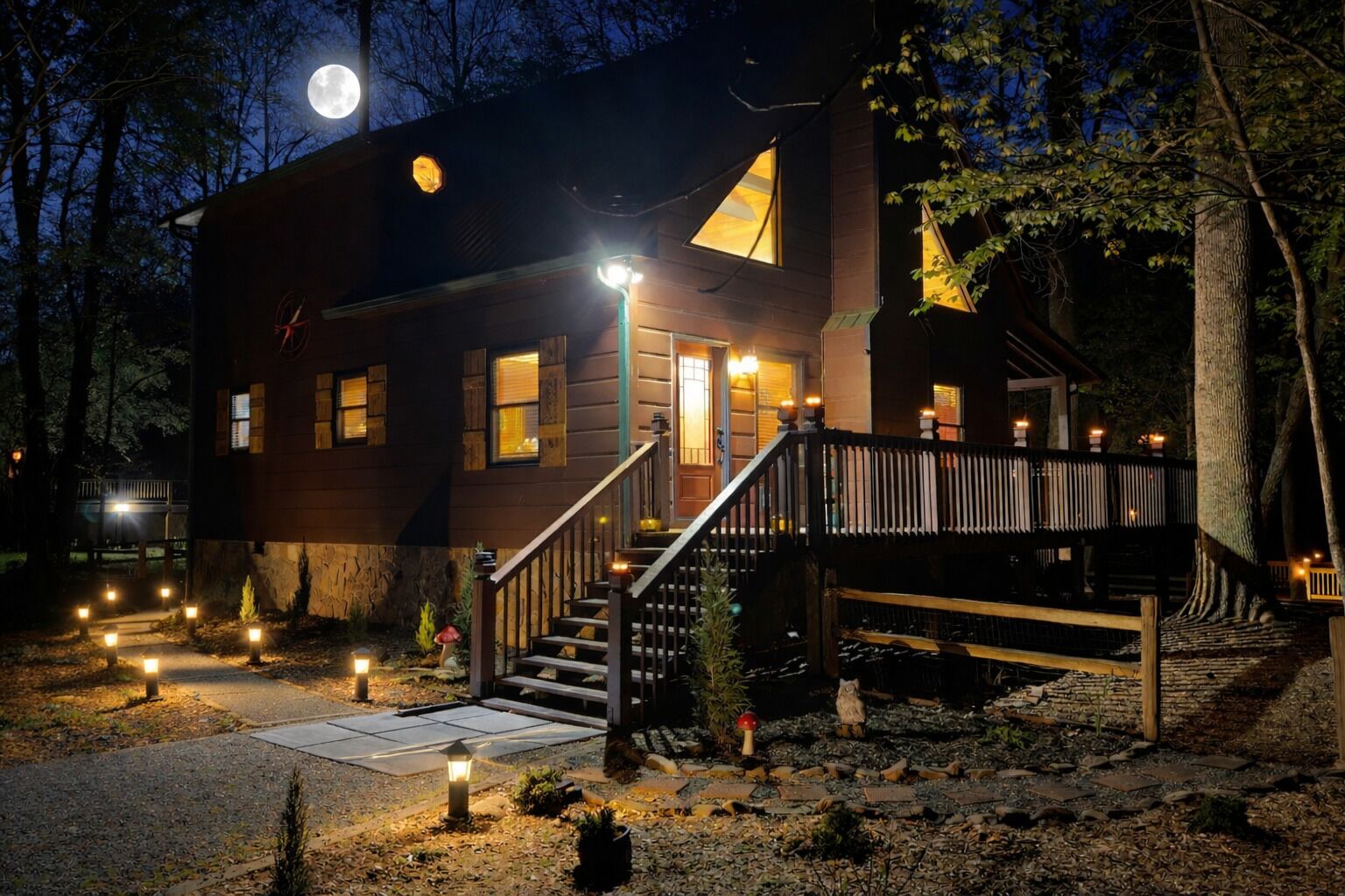 Una cabaña de madera con escaleras, una terraza y una luna llena al fondo.