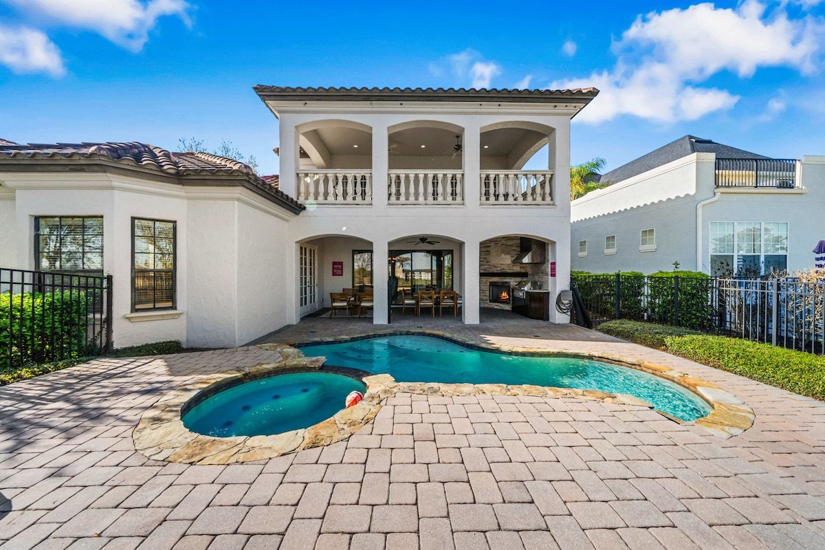 A two-story house with a swimming pool and outdoor seating area.
