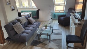 Un salon moderne comprenant un canapé, une table basse et un coin repas avec une table et des chaises.