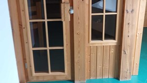 Une porte en bois avec un panneau de verre, un mur en bois et un plancher de couleur turquoise.