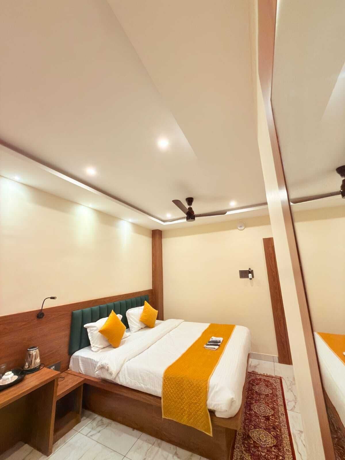 A hotel room with a bed, bedside table, and a ceiling fan.