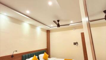 A hotel room with a bed, bedside table, and a ceiling fan.