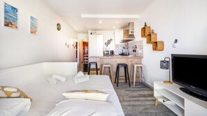 A hotel room with a bed, a TV, a kitchen area, and a bar. - Air-conditioned studio with sea view and pool (Antibes)