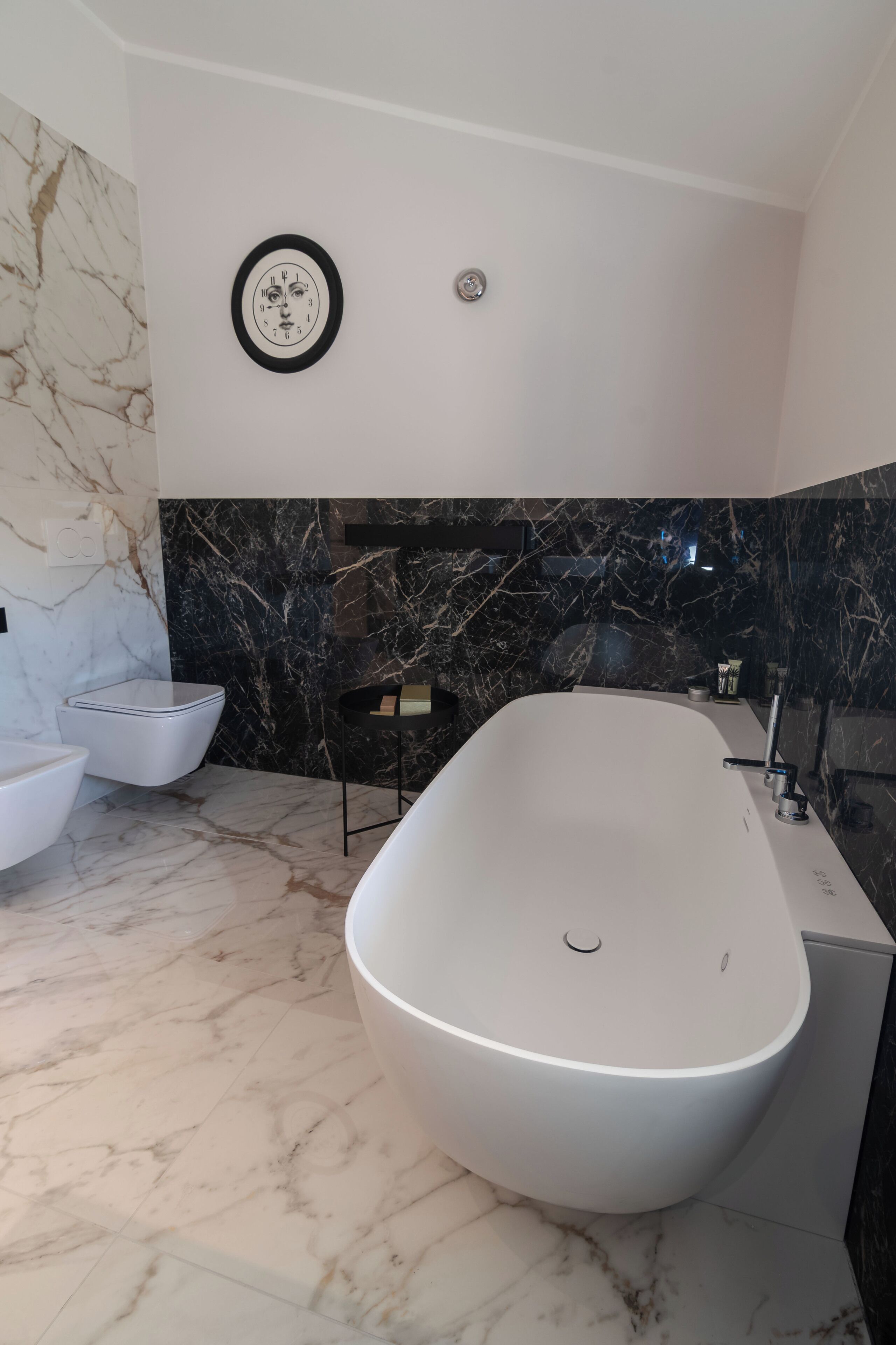 A modern bathroom with a freestanding bathtub, a toilet, and a vanity.