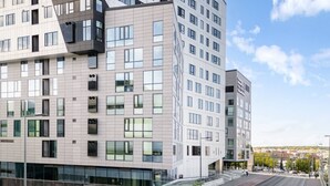 A modern multi-story building with a grid of windows, a flat roof, and a wide street in front. - Nokia Arena By Come in! Deluxe Family Room (Tampere)