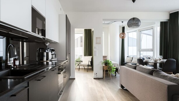 A modern kitchen with a dining area, a sofa, and a dining table. - Nokia Arena By Come in! Deluxe Family Room (Tampere)