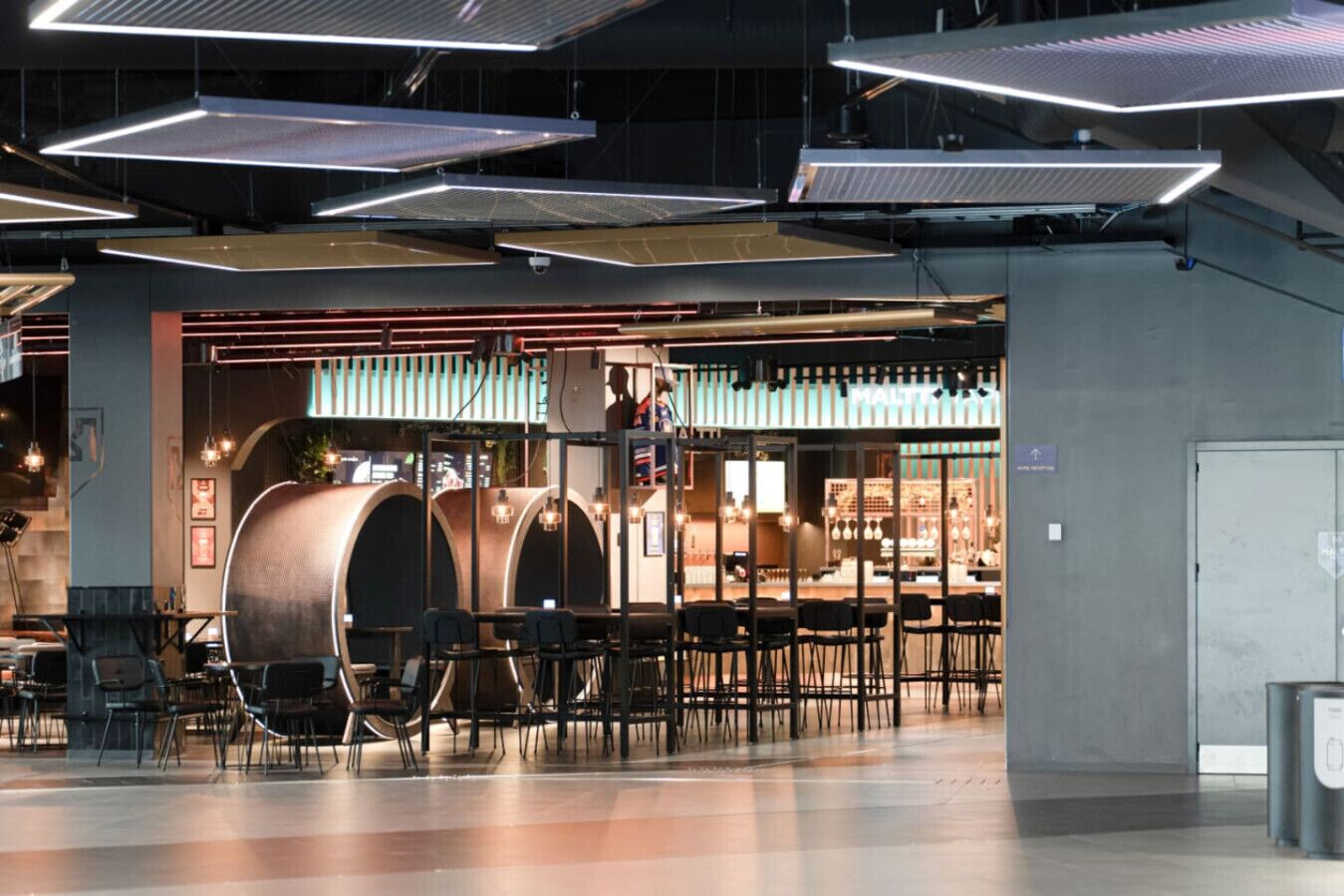 A modern interior with exposed ductwork, a bar area, and seating.