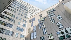 A multi-story building with a modern architectural design, featuring large windows and a grid-like facade.