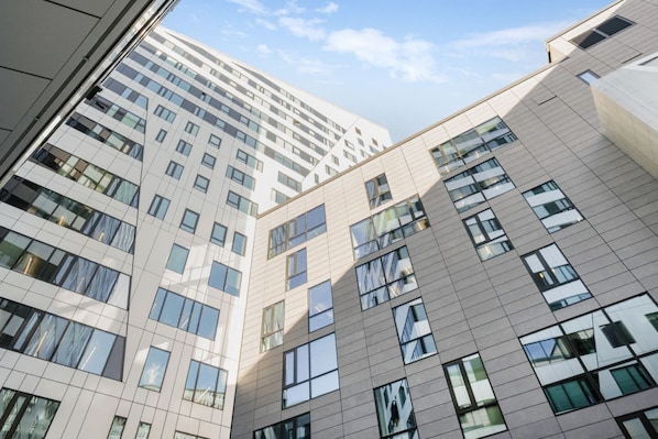 A multi-story building with a modern architectural design, featuring large windows and a grid-like facade.