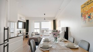 Una habitación de hotel moderna con comedor, cocina y sala de estar.