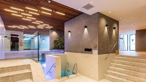 A modern indoor pool area with steps leading to a pool, a wooden ceiling, and a glass wall. - 2 Spacious Wellness Retreat | Spa, Pool & Resort Access | Beach & Nature Park (Kamperland)