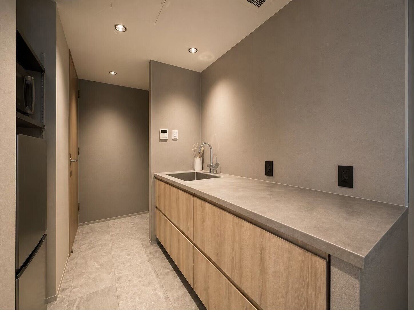 A modern bathroom with a large mirror, a sink, and a wooden vanity.