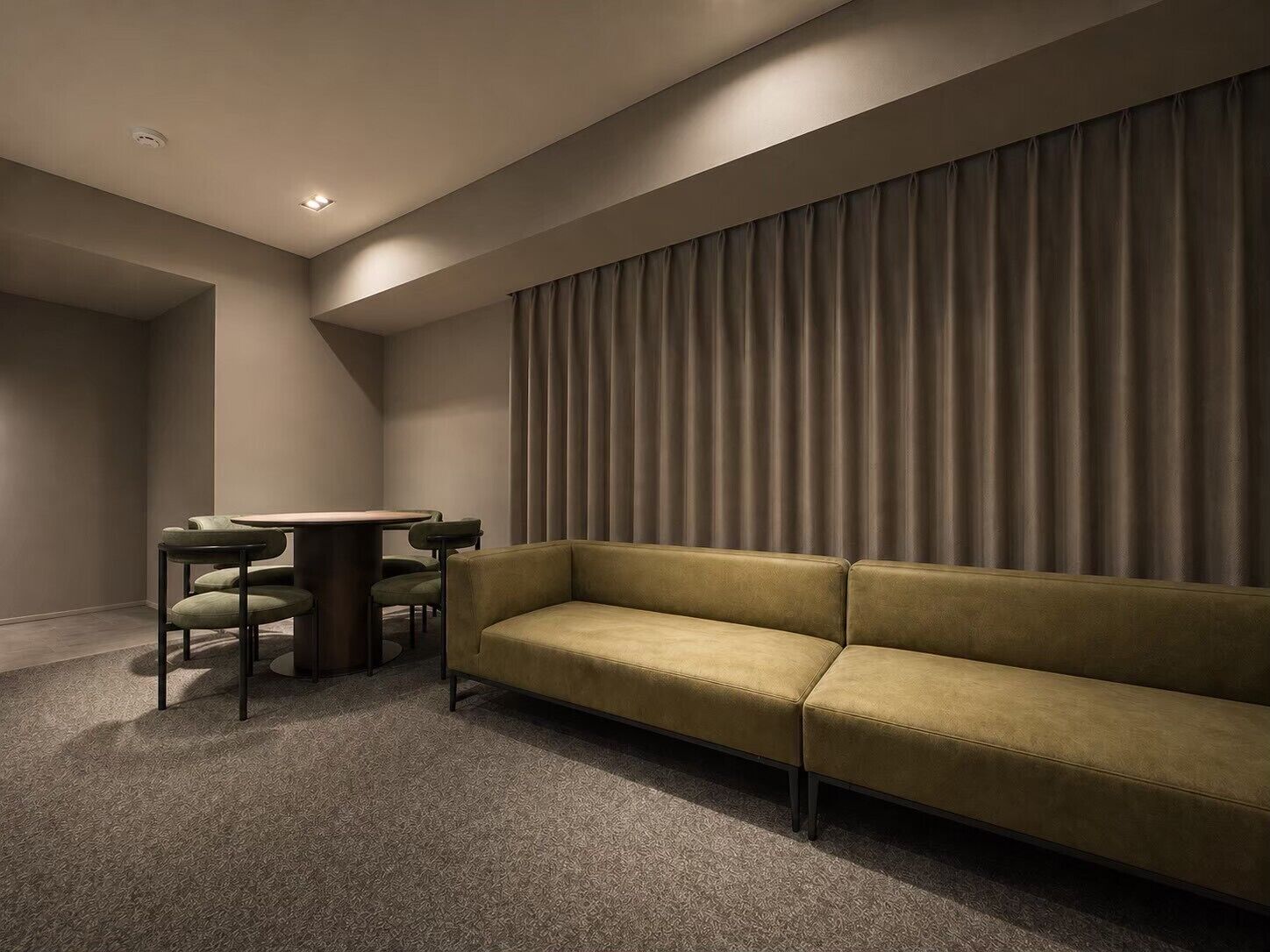 A modern room with a sofa, a small table, and chairs.