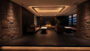 Ein modernes Interieur mit Kamin, Ledersofas und Steinmetzarbeiten an der Wand.
