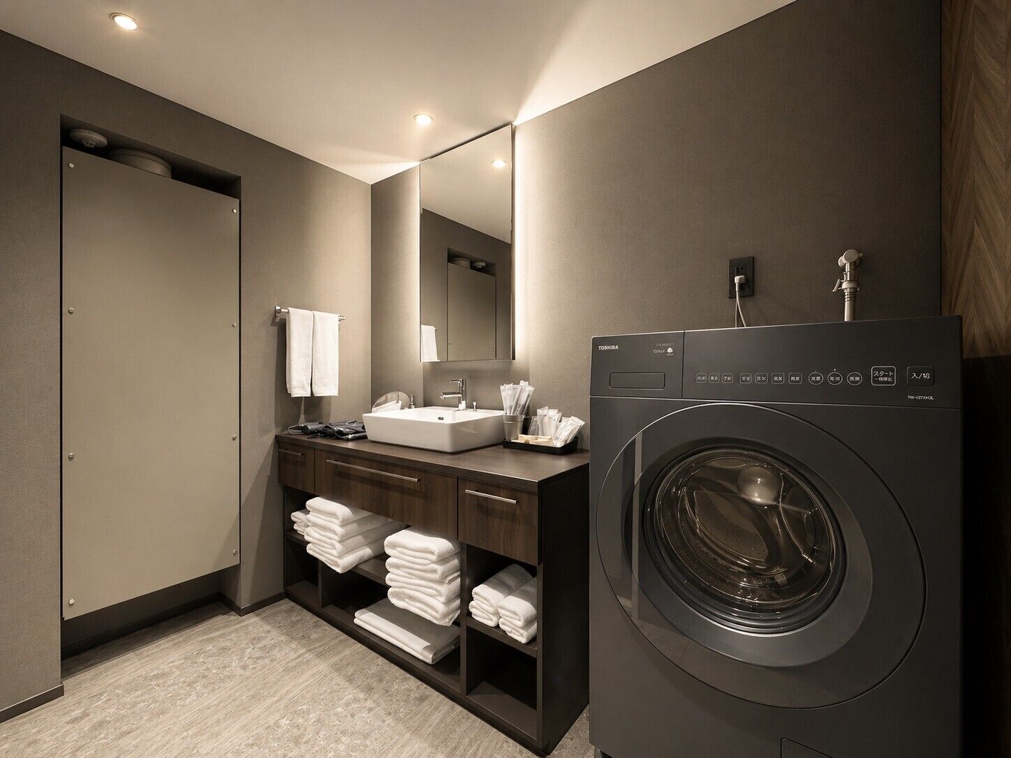 A modern bathroom with a washing machine, a sink, and a mirror.